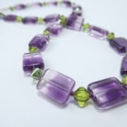 Détail du collier mauve et vert.