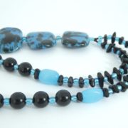 Détail du collier avec pendentif noir et bleu.