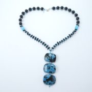 Collier avec pendentif noir et bleu.
