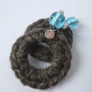 Boucles d'oreilles en laine avec perle bleue.