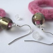 Détail des crochets d'oreilles en laine rose.