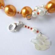 La breloque oiseau du bracelet orange.