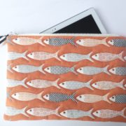 La pochette matelassée de couleur corail avec motif poisson.