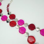 Les perles rouges et rose fluo séparées par des perles métalliques.