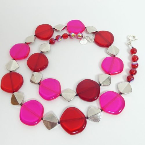 Le collier rouge et rose fluo a aussi des perles métalliques.