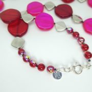 Détail du fermoir du collier rouge et rose fluo.