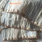 Finition crochetée couleur caramel pour l'écharpe à rayures bleues.