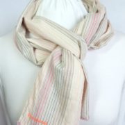 L'écharpe en tissu à rayures roses avec finition crochetée rose.