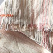 Les franges de l'écharpe en tissu à rayures roses.