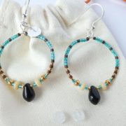 Boucles d'oreilles bleu sarcelle avec un pendant en forme de goutte noire.