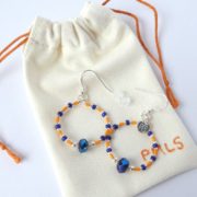 Les boucles d'oreilles bleues et orange sur leur pochon en flanelle.