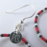 Le crochet des boucles d'oreilles blanc nacré, rouges et noires.