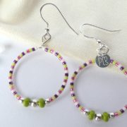 Boucles d'oreilles vertes et roses sur leur pochon en flanelle.