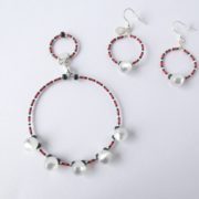 Le bracelet blanc nacré rouge et noir et les boucles d'oreilles assorties.