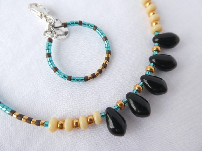 Les perles noires en forme de goutte du bracelet bleu sarcelle.