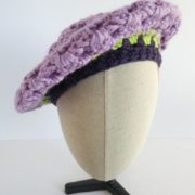 Le béret mauve porté penché sur le côté.
