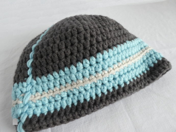Gros plan du bonnet gris et bleu en laine.