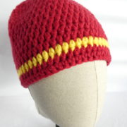 Un bonnet crocheté en laine rouge avec une rayure jaune.