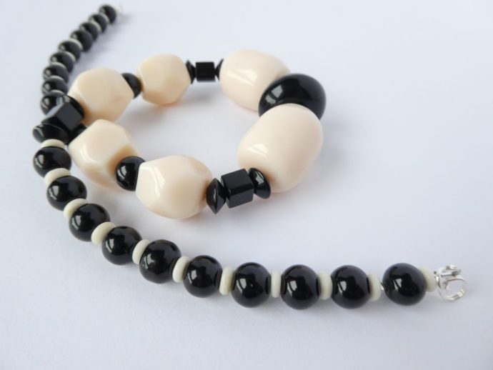 Les grosses perles en résine du collier art déco noir et crème.
