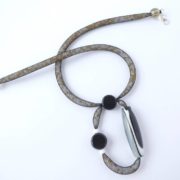 Le pendentif asymétrique du collier en résille tubulaire noire.