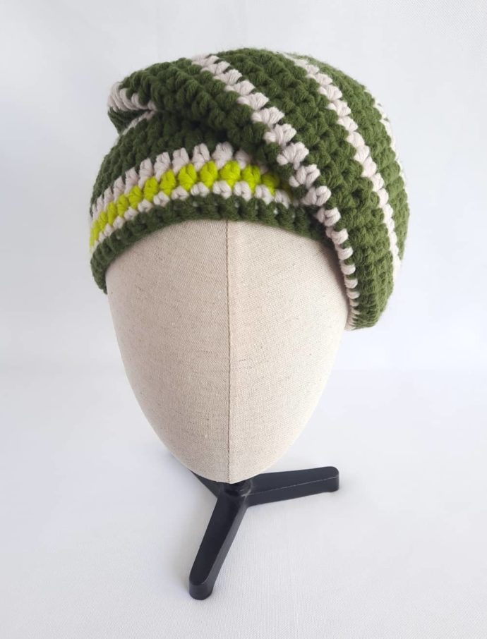 Le bonnet vert et écru en laine Huelgoat en version penchée sur le côté.
