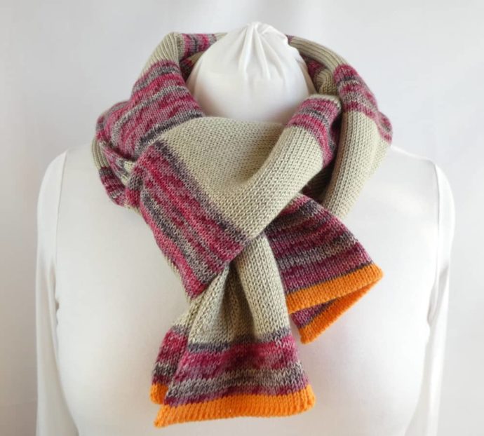 L'écharpe en laine fine à rayures chanvre et rose foncé.