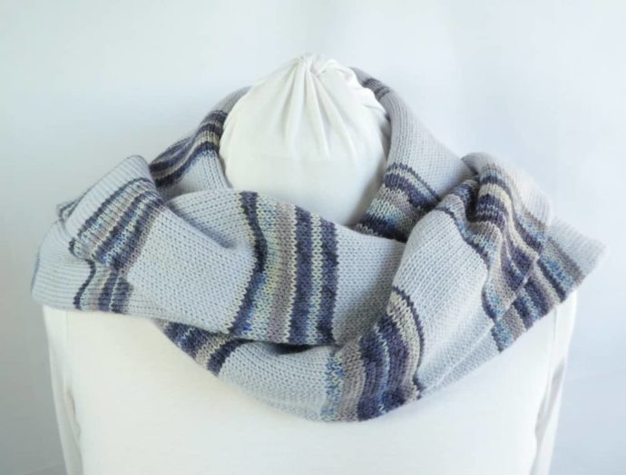 L'écharpe en laine fine à rayures bleues portée sur les épaules.