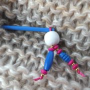 Gros plan sur les perles en bois du bijou d'écharpe bleu.