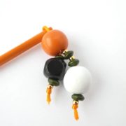 Les perles en bois du bijou d'écharpe orange.