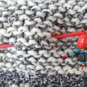 Le bijou d'écharpe rouge piqué dans une grosse écharpe Pamalussi;