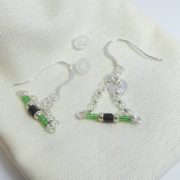 Les embouts et le pochon en coton des boucles d'oreilles vertes avec chaîne argent.