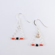 Les boucles d'oreilles rouges avec chaîne argent.