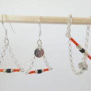 Le bracelet rouge et chaîne argent et les boucles d'oreilles assorties.