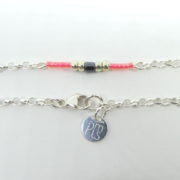 Le fermoir Menotte et la marque PMLS du bracelet rose avec chaîne argent.