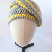 Le bonnet gris et jaune Pantone 2021 porté sur le côté de la tête.