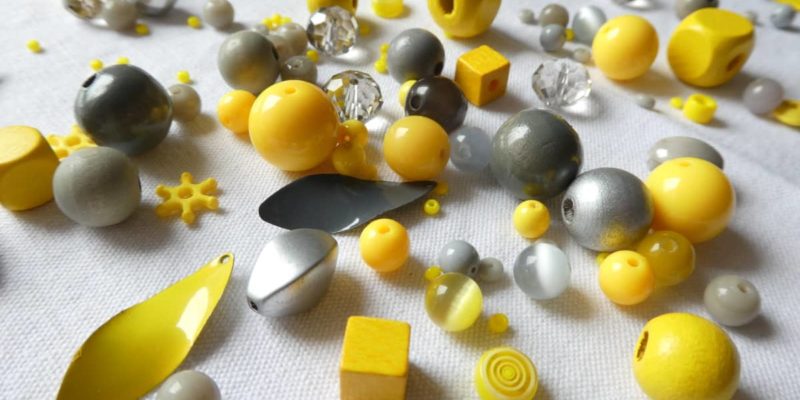 Un assortiment de perles pour le collier jaune et gris Pamalussi.