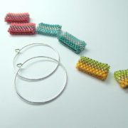 Les créoles Alice en argent 925 et les pendants de perles tissées de couleurs toniques.
