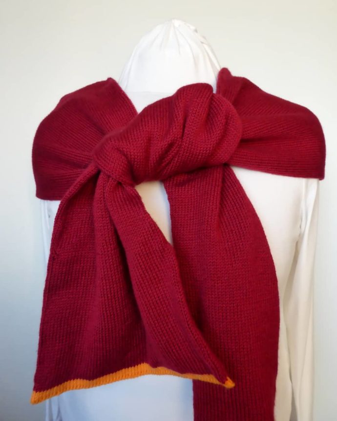 L'écharpe en laine fine rouge carmin peut se nouer de plusieurs façons.