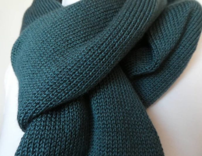 Gros plan sur le point de jersey utilisé pour l'écharpe en laine fine vert cobalt.