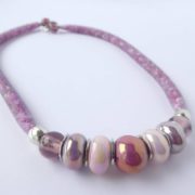 Le collier Apolline est en résille tubulaire garni de petites perles mauves.