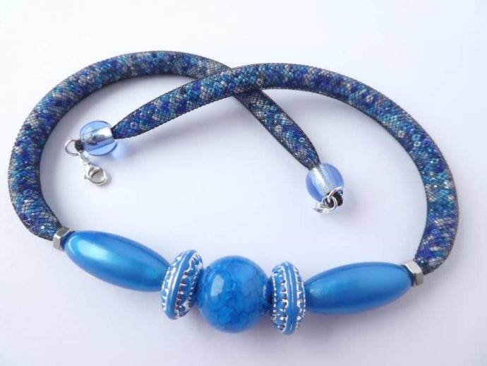 Les perles bleu ciel du centre du collier bleu étoilé.