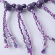 Des perles translucides sont cousues sur le cordon du collier Valentine lilas rose.