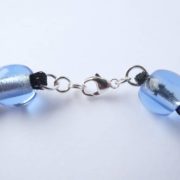 Le fermoir du collier bleu étoilé en résille tubulaire.