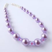 Le collier glycine rose a des perles de style renaissance.
