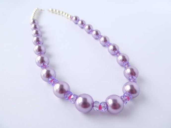 Le collier glycine rose a des perles de style renaissance.