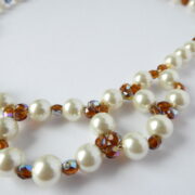 Gros plan sur les perles nacre et ambre du collier Chloé.