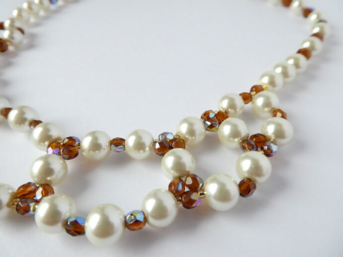 Gros plan sur les perles nacre et ambre du collier Chloé.