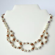 Le collier Chloé nacre et ambre sur un présentoir.
