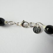 La marque PMLS et le fermoir en argent 925 du collier Garance bleu et noir.