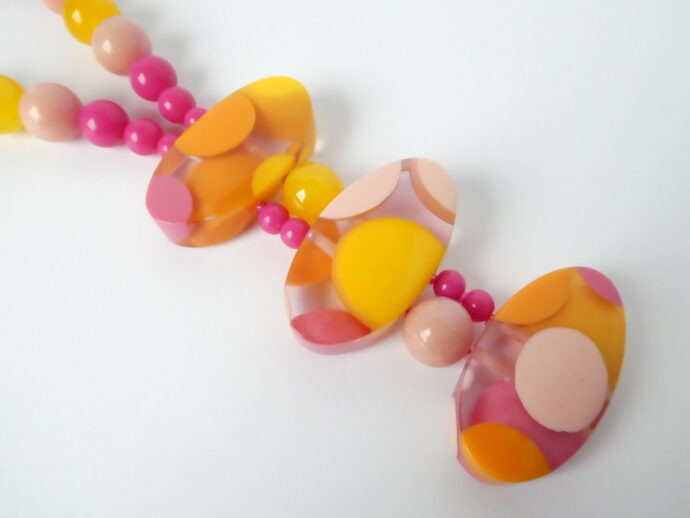 Les trois perles palets du pendentif du collier Lola jaune et rose.